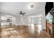 Bright open floor plan living room with fireplace, ceiling fan, wood floors, and view to the kitchen at 505 Summer Ter, Woodstock, GA 30189