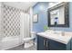 A blue bathroom featuring black hexagon tile, a white toilet, and a white tub with black and white tile wall at 260 18Th Nw St # 10202, Atlanta, GA 30363