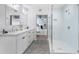 Clean and bright bathroom featuring dual sinks, a glass shower, and a glimpse into the main bedroom at 260 18Th Nw St # 10202, Atlanta, GA 30363