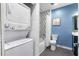Bright bathroom featuring a stacked washer/dryer, black and white patterned walls, and a shower-tub combo at 260 18Th Nw St # 10202, Atlanta, GA 30363
