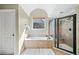 Well-lit bathroom with a shower, bathtub, and an arched ceiling at 404 N Cascades Cir, Canton, GA 30114
