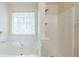 Bathroom featuring large soaking tub with tiled walls and separate glass shower with window at 445 Skif Pond Ct, Atlanta, GA 30349