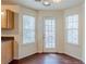 Bright dining area featuring dark hardwood floors, natural light, and a rear exterior door at 445 Skif Pond Ct, Atlanta, GA 30349