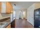 Kitchen showing wood cabinets and black appliances; view of adjoining rooms at 445 Skif Pond Ct, Atlanta, GA 30349