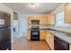 Spacious kitchen featuring light wood cabinets and black appliances at 445 Skif Pond Ct, Atlanta, GA 30349
