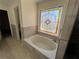 Bathroom with soaking tub and decorative stained glass window at 4960 Trevino Cir, Duluth, GA 30096