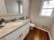 Bathroom featuring hardwood floors, vanity with marble countertop and silver framed mirror at 4960 Trevino Cir, Duluth, GA 30096