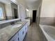 Bathroom featuring double sinks, soaking tub, and elegant tile work at 4960 Trevino Cir, Duluth, GA 30096