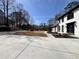 Long concrete driveway leads to a white two-story home with black trim and large green space at 4960 Trevino Cir, Duluth, GA 30096