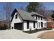 A two-story white home features dark trim, a side-entry garage, and manicured landscaping at 4960 Trevino Cir, Duluth, GA 30096
