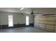 A clean, bright garage featuring fresh paint, paneled walls, windows and an automatic door at 4960 Trevino Cir, Duluth, GA 30096