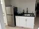 Cozy kitchenette features a stainless-steel fridge and white cabinets with black countertop and modern gold hardware at 4960 Trevino Cir, Duluth, GA 30096