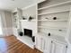 Living room showcasing a white brick fireplace, built-in bookshelves, and hardwood floors at 4960 Trevino Cir, Duluth, GA 30096