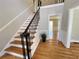 Elegant staircase features hardwood steps, decorative iron railings, and views of the foyer and doorway at 4960 Trevino Cir, Duluth, GA 30096