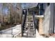 Exterior stairway leads to a second story balcony with black metal railings and stone supports to the balcony above at 4960 Trevino Cir, Duluth, GA 30096