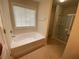 Bright bathroom with a soaking tub and a separate glass-enclosed shower at 2453 Suwanee Pointe Dr, Lawrenceville, GA 30043