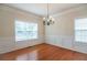 Bright dining room with hardwood floors, wainscoting, and a classic chandelier at 2453 Suwanee Pointe Dr, Lawrenceville, GA 30043