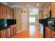 Open kitchen with wood cabinets, stainless appliances, and black countertops at 2453 Suwanee Pointe Dr, Lawrenceville, GA 30043