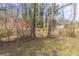 View of the backyard featuring trees, surrounding foliage, and a glimpse of neighboring houses at 2973 Cambridge Sw Dr, Atlanta, GA 30331