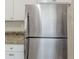 Close up of a stainless steel refrigerator next to white cabinets and light granite countertops at 2973 Cambridge Sw Dr, Atlanta, GA 30331