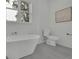Bright bathroom featuring a modern soaking tub, toilet, and a neutral color palette at 830 Gaston Street Sw, Atlanta, GA 30310