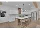 Spacious kitchen with white cabinets, stainless steel appliances, a large island with seating, and hardwood floors at 830 Gaston Street Sw, Atlanta, GA 30310
