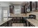 Well-equipped kitchen featuring granite countertops, dark cabinetry, and modern appliances at 2154 Dodson Woods Dr, Fairburn, GA 30213