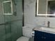 Modern bathroom with sleek glass shower, marble-look tile, illuminated mirror, and stylish blue vanity at 6051 Wintergreen Rd, Norcross, GA 30093