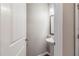 A half bathroom features a pedestal sink, stylish mirror, and classic white woodwork at 811 Lake Chase, Fairburn, GA 30213