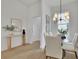 Bright dining room with a glass table, white chairs, and a modern light fixture next to an entryway at 826 Gaston Street Sw, Atlanta, GA 30310