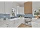 Well-appointed kitchen featuring white cabinetry, stainless steel appliances, and blue tile backsplash at 826 Gaston Street Sw, Atlanta, GA 30310