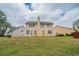 Backyard featuring a spacious lawn, mature trees and the exterior of a tan house at 104 Shadow Creek Ct, Fairburn, GA 30213