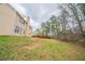 Spacious backyard with trees, a gentle slope and the side of a tan house with a chimney at 104 Shadow Creek Ct, Fairburn, GA 30213