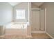 Bright bathroom featuring a soaker tub and separate glass shower at 104 Shadow Creek Ct, Fairburn, GA 30213