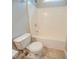 Bright bathroom featuring a toilet next to a shower and tub combo with neutral tile floors at 104 Shadow Creek Ct, Fairburn, GA 30213