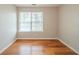 Bedroom with hardwood floors and a window overlooking a green space at 104 Shadow Creek Ct, Fairburn, GA 30213
