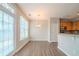 Bright dining area adjacent to kitchen with hardwood floors and modern pendant light at 104 Shadow Creek Ct, Fairburn, GA 30213