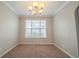Inviting dining room features a window, carpet, and stylish chandelier at 104 Shadow Creek Ct, Fairburn, GA 30213