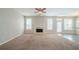 Spacious living room with a cozy fireplace, plush carpeting, and abundant natural light at 104 Shadow Creek Ct, Fairburn, GA 30213