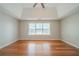 Serene main bedroom with tray ceilings, a ceiling fan, and hardwood floors at 104 Shadow Creek Ct, Fairburn, GA 30213