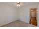 A cozy bedroom with neutral carpet, a ceiling fan, and a doorway that leads to another room at 110 Eastfield Ct, Mcdonough, GA 30252