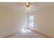 An empty bedroom features carpeted floors and a ceiling fan with light, brightened by natural light through the window at 110 Eastfield Ct, Mcdonough, GA 30252