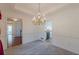 Dining room showing entryway to kitchen, carpet, and classic chandelier at 110 Eastfield Ct, Mcdonough, GA 30252