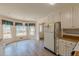 Sunny eat-in kitchen area with wood floors, white cabinets, and backyard views at 110 Eastfield Ct, Mcdonough, GA 30252