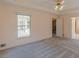 A bright bedroom with a ceiling fan, plush carpet, and a view of the deck through a large window at 110 Eastfield Ct, Mcdonough, GA 30252
