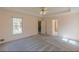 A bright bedroom with a ceiling fan, plush carpet, and a view of the deck through a large window at 110 Eastfield Ct, Mcdonough, GA 30252