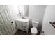 Compact bathroom featuring a toilet, sink, and decorative mirror at 5582 Windwood Rd, Atlanta, GA 30349