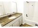 Bathroom featuring granite countertop and a shower-tub combo at 5582 Windwood Rd, Atlanta, GA 30349