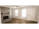 Living room with a fireplace, two windows, and hardwood floors at 5582 Windwood Rd, Atlanta, GA 30349
