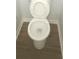 Close up view of a standard white toilet on wood-look vinyl flooring at 5582 Windwood Rd, Atlanta, GA 30349